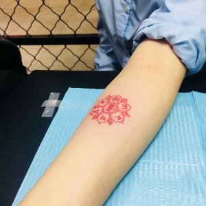 美容博主陈小姐手臂上的红色圆形纹身图案