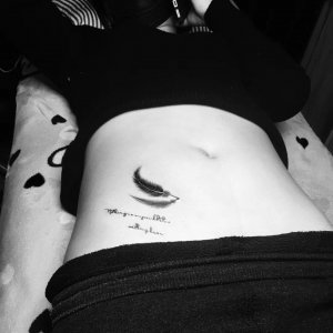 健美操教练李小姐腹部的黑色羽毛文字纹身图案
